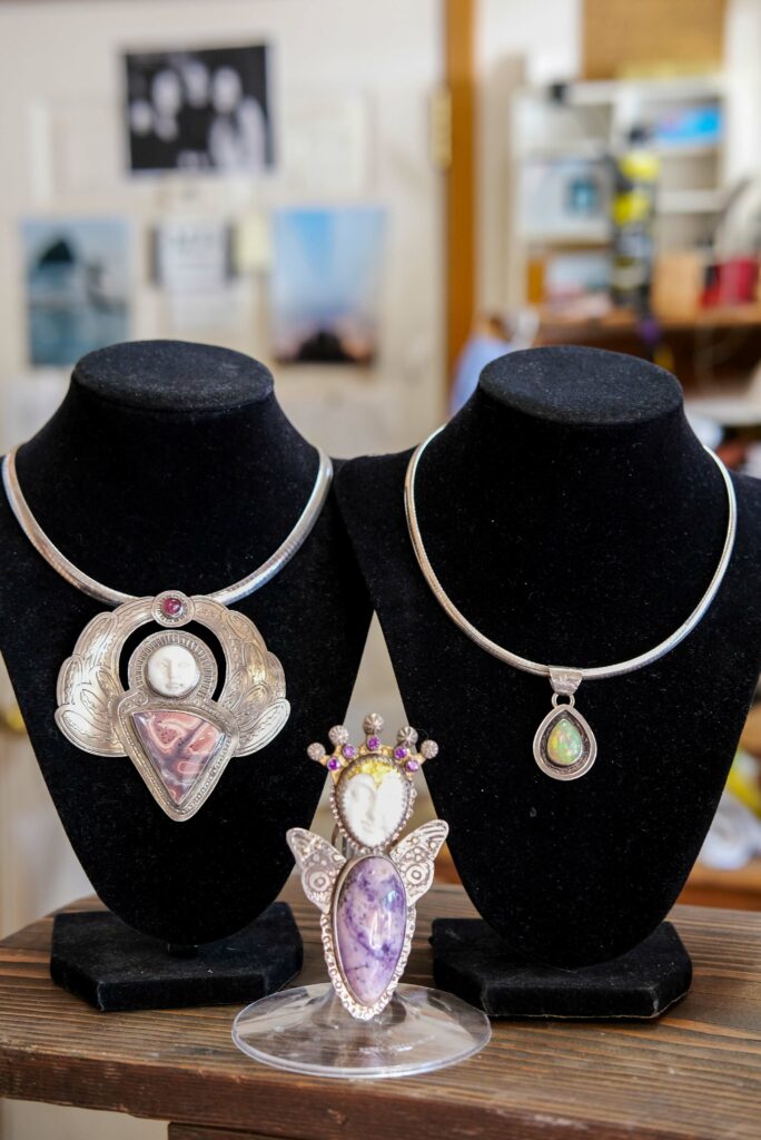 Three bold statement necklaces with large stones and white carved stone faces.