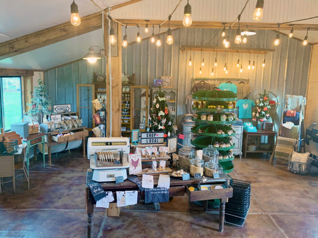 A retail shop decorated festively for the holidays.  Warm bistro lights are strung across the beams of the ceiling.