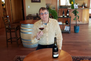 Jacques Rendu holds a glass of red wine from Coeur de Terre.