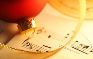 Sheet music with a gold ribbon and red ornament.