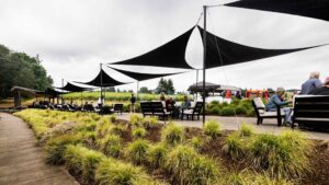 An outdoor patio with black sun shades over patio furniture.