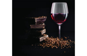 A glass of red wine with a stack of chocolate bars
