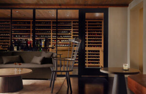 Sleek, plush and modern bar furniture with a wine storage room in the background.